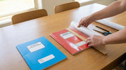  Parent covering a school exercise book with clear contact film