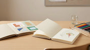 Scrapbook and visual art diary displayed with school art supplies